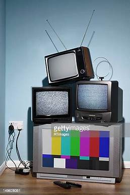 Old TVs stacked in a corner